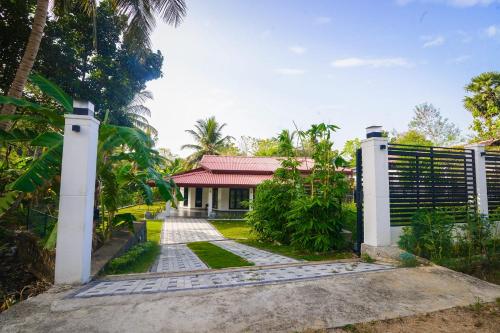 a gate leading to a house with a fence at ayaan group house in Ampara