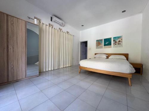 Un dormitorio con una cama y un espejo grande. en Villa central seminyak, en Seminyak