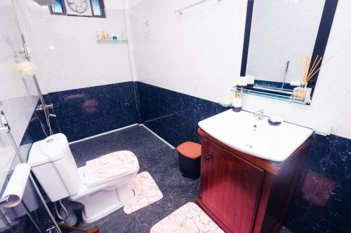 a bathroom with a white toilet and a sink at ayaan group house in Ampara