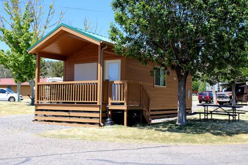 a small cabin with a porch and a tree at Verde Valley Deck Cottage 8 in Cottonwood