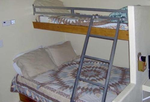 a bunk bed in a room with a ladder at Verde Valley Studio Park Model Cabin 16 in Cottonwood