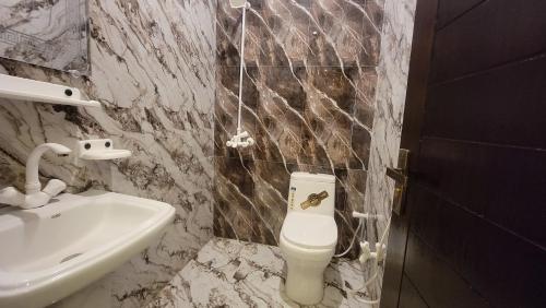 a bathroom with a toilet and a sink at Hotel Elegant Gulshan-e-Iqbal karachi in Karachi