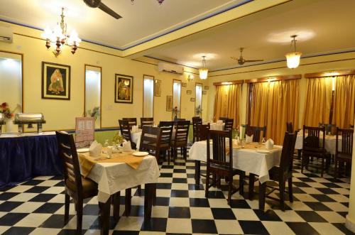 a restaurant with tables and chairs and a checkered floor at Koolwal Kothi Zinc Journey by The Fern, Nawalgarh, Rajasthan in Nawalgarh