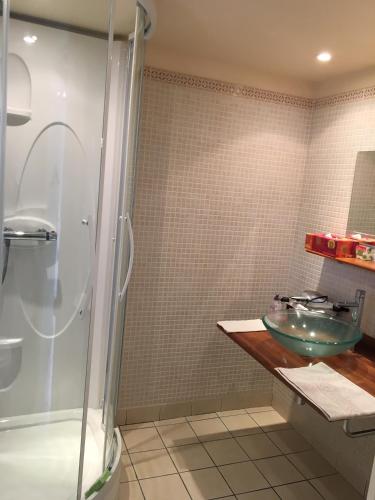 La salle de bains est pourvue d'un lavabo en verre et d'une douche. dans l'établissement La Pomme de nuit, à Bayeux