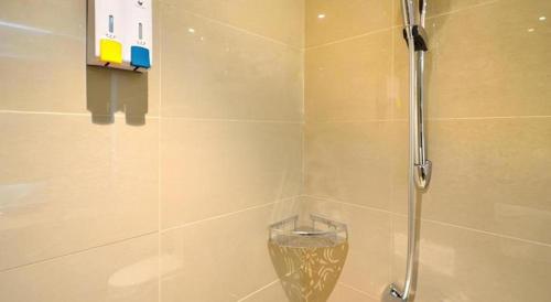 a bathroom with a shower with a glass door at City Comfort Inn Lichuan Railway Station Jimi Home in Enshi