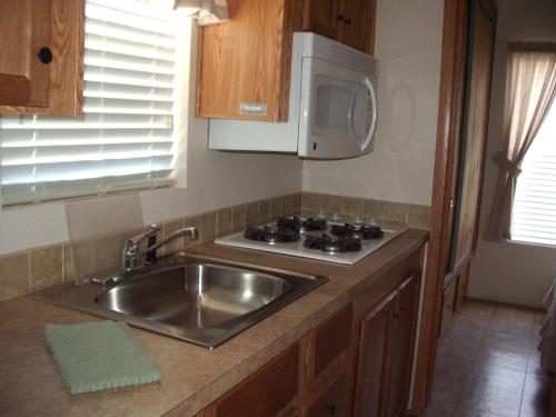 a kitchen with a sink and a microwave at Verde Valley One-Bedroom Park Model Cabin 13 in Cottonwood
