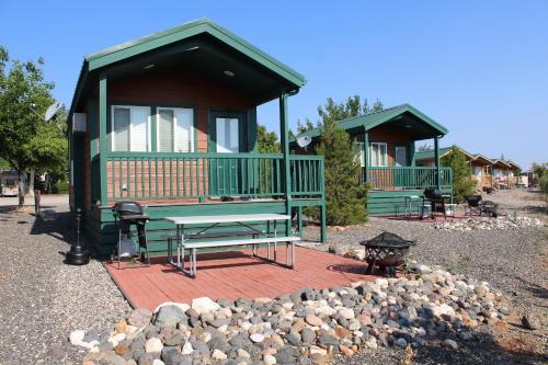 a green cabin with a picnic table and a grill at Verde Valley Studio Cabin 2 in Cottonwood