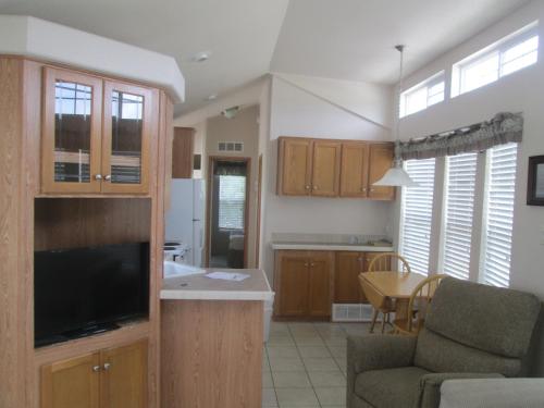 a kitchen and living room with a couch and a television at Lake Magic Park Model 15 in Kissimmee