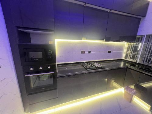 a kitchen with a stove and a microwave at MedeHeights Apartments in Abuja
