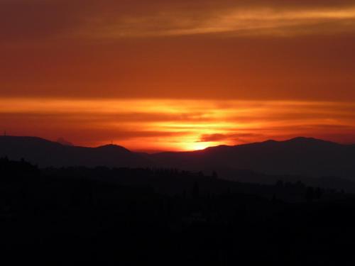 a sunset over the mountains with the sun setting at Il Casalone in Impruneta