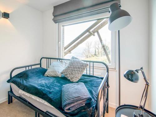 a bed sitting in a room with a window at Holiday home in HUY near town center in Huy