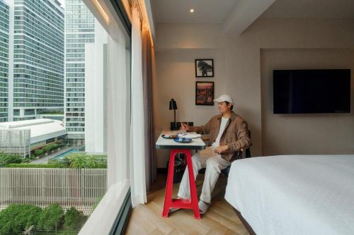 a man sitting at a table in a hotel room at Four Points by Sheraton Bangkok, Sukhumvit 22 in Bangkok