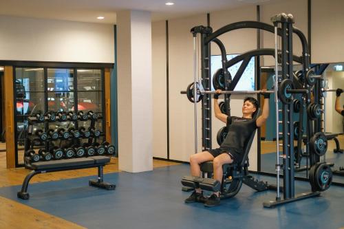 a woman is in a gym doing squats at Four Points by Sheraton Bangkok, Sukhumvit 22 in Bangkok