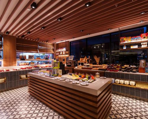 a restaurant with a table with food on it at Four Points by Sheraton Bangkok, Sukhumvit 22 in Bangkok
