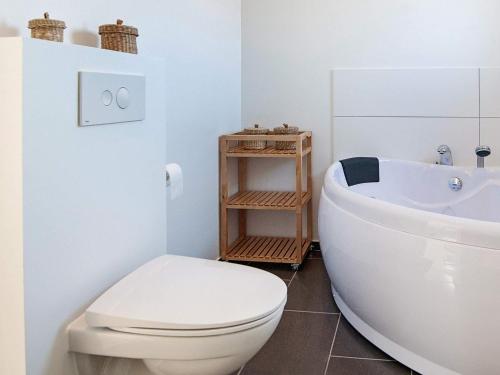 a white bathroom with a toilet and a sink at 14 person holiday home in Glesborg-By Traum in Glesborg