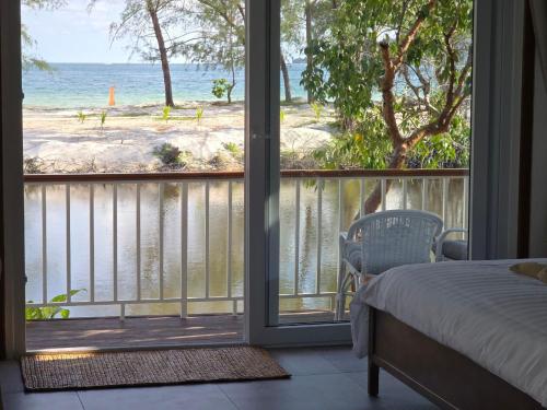 a bedroom with a bed and a view of the ocean at White Beach Resort Longset in Koh Rong Island