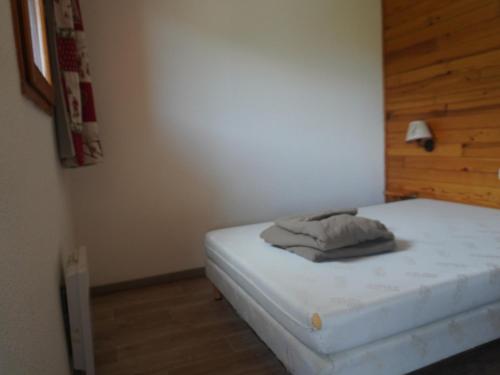 a bedroom with a white bed with a wooden wall at Appartement 6 pers, 2 ch, proche pistes et commerces - FR-1-807-123 in Saint-François-Longchamp