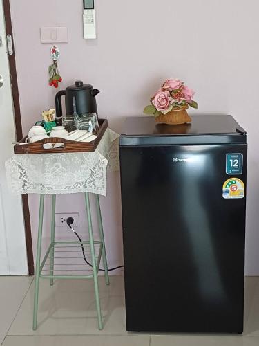 a kitchen with a table and a refrigerator and a table at 168Hostel Airport@Phuket in Thalang