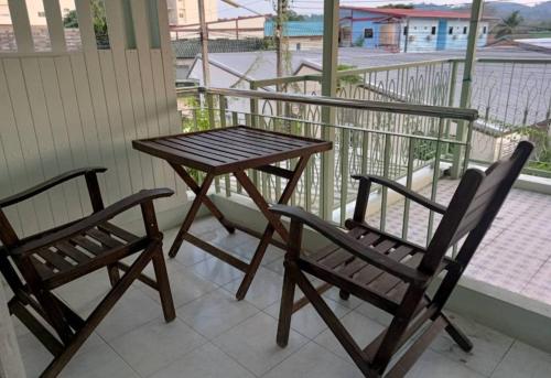two chairs and a wooden table on a balcony at 168Hostel Airport@Phuket in Thalang