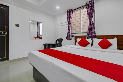 a bedroom with a large white bed with red pillows at Hotel O Bhekrai Nagar Bus Terminal Formerly Silver Star in Phūrsungi