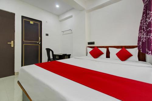 a bedroom with a large white bed with red pillows at Hotel O Bhekrai Nagar Bus Terminal Formerly Silver Star in Phūrsungi