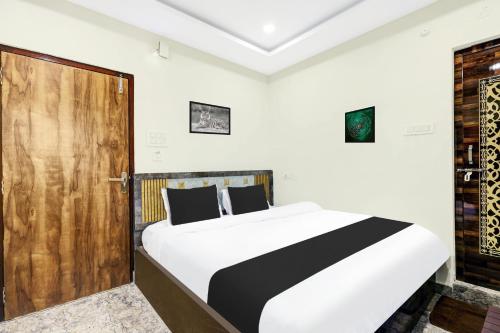a bedroom with a bed and a wooden door at Super Hotel O Vizianagaram Near Railway Station in Vizianagram City