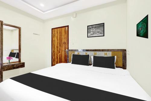 a bedroom with a large bed and a mirror at Super Hotel O Vizianagaram Near Railway Station in Vizianagram City