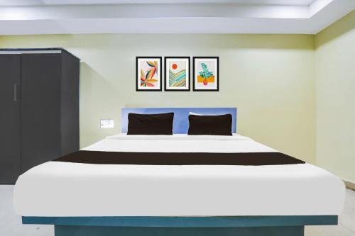 a bedroom with a large white bed with two pillows at Collection O Nellore Subbareddy Government Hospital Formerly Hotel Rama Royal in Nellore