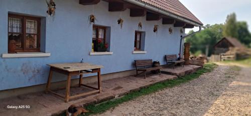 a house with two benches and a table in front of it at Farma Hermína in Jilemnice