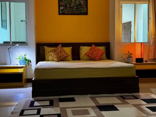 a bedroom with a large bed with orange walls at Aonang Private House in Ao Nang Beach