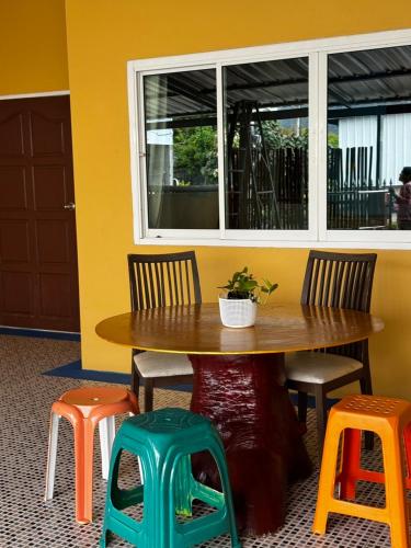 a table with chairs and a table with a plant on it at Aonang Private House in Ao Nang Beach