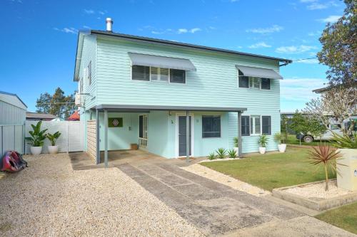 a blue house with a driveway in front of it at Riverside Retreat in Harrington