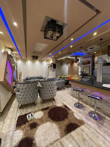 a living room with couches and a tv and a kitchen at pyramids in ‘Ezbet `Abd el-Ḥamîd