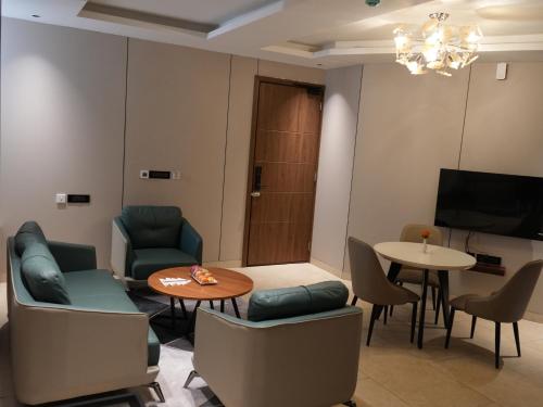 a living room with chairs and a table and a tv at Sportico Resort Bangalore in Mālūr