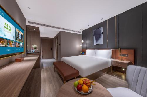 a hotel room with a bed and a tv at Orange Hotel, Maliandao, Lize Business District, Beijing in Beijing