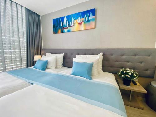 a bedroom with a large bed with blue and white pillows at Oceanami Villa 3PN, bếp và BBQ in Long Hai