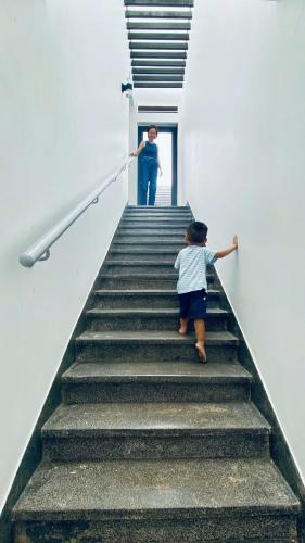 a man and a child walking up the stairs at Oceanami Villa 3PN, bếp và BBQ in Long Hai