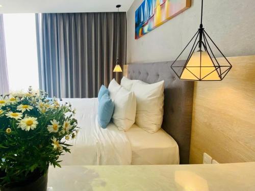 a hotel room with a bed and a vase of flowers at Oceanami Villa 3PN, bếp và BBQ in Long Hai