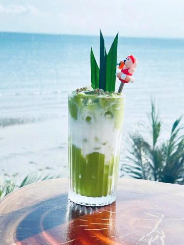 a drink sitting on a table on the beach at Bay View Beach Villas Mũi Né in Ấp Khánh Phước (1)