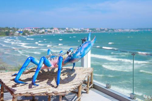 a statue of a crab sitting on top of a table next to the ocean at Bay View Beach Villas Mũi Né in Ấp Khánh Phước (1)