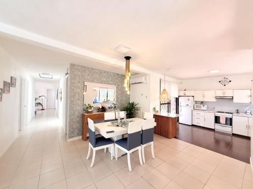 Una cocina y una sala de estar con mesa y sillas. en Las palmeras con piscina, en Playas