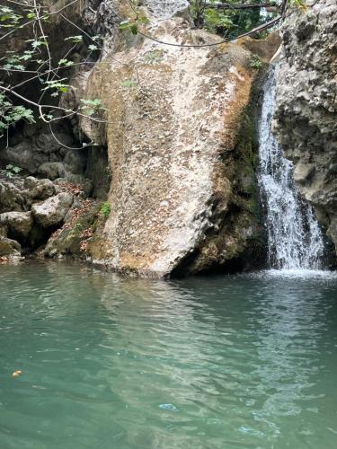a waterfall on the side of a rocky cliff at Chalet Dirfys - Escape in the heart of Evia in Kambiá