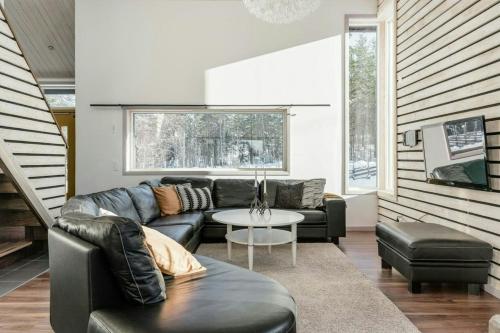 a living room with a couch and a table at Spacious Mountain Cabin With Jacuzzi In Kläppen in Transtrand