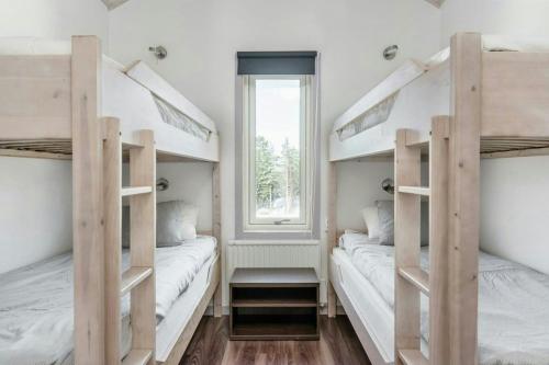 two bunk beds in a room with a window at Spacious Mountain Cabin With Jacuzzi In Kläppen in Transtrand