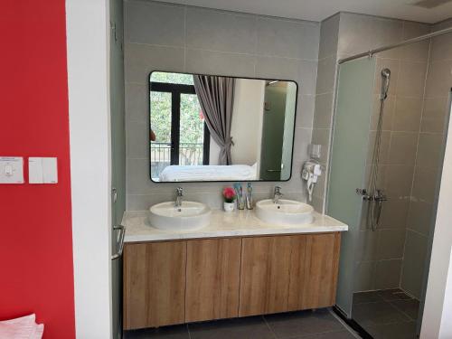 une salle de bain avec deux lavabos et un miroir dans l'établissement Homestay Ocean City, Kinh Đô 5-15, à Ðình Loan
