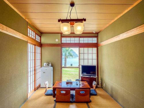 a living room with a table and a television at Sea Tiger Island Inn Shodoshima in Shodoshima