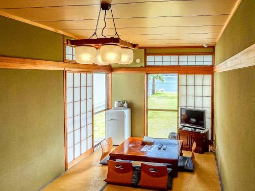 a living room with a table and a refrigerator at Sea Tiger Island Inn Shodoshima in Shodoshima