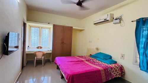 Un dormitorio con una cama con una manta rosa. en A2C homestay in Pondicherry, en Auroville