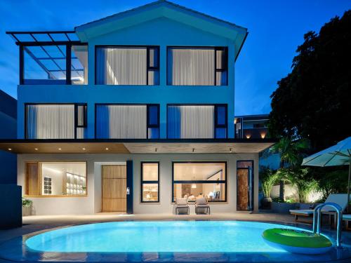 a house with a swimming pool in front of it at 涠洲岛隐拙山与澜海景酒店 in Weizhouxu
