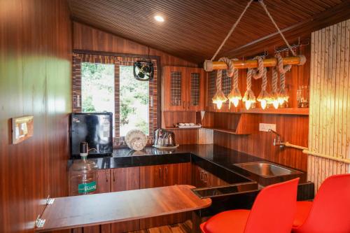 a kitchen with a sink and red chairs in it at Le Karaj Meadows in Lovedale